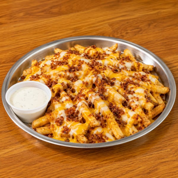 Loaded fries with melted cheese and bacon bits, served with a side of ranch dressing.